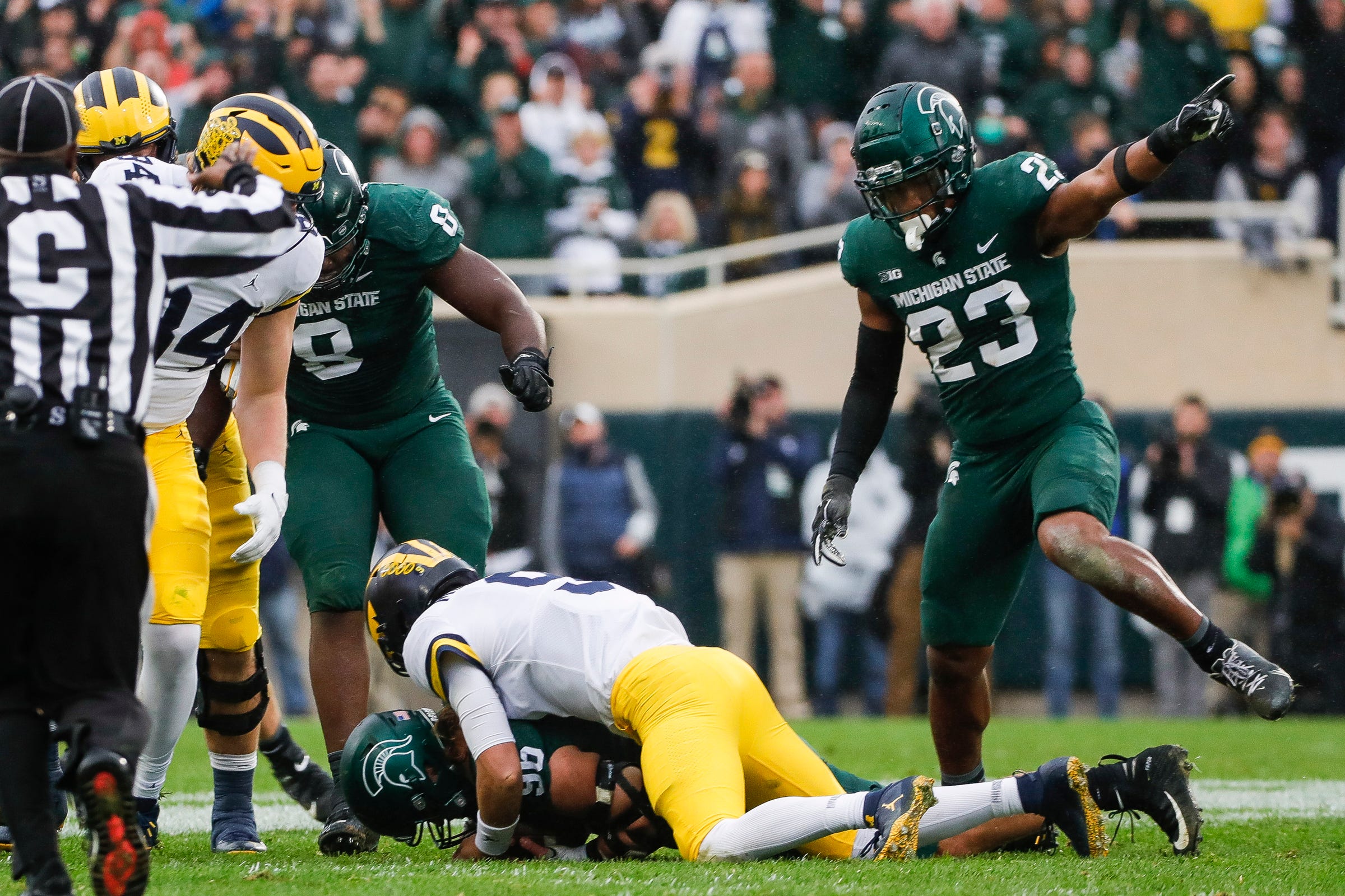 Michigan State Football Player Darius Snow signals for his team to have possession of the football in a game against the Michigan Wolverines