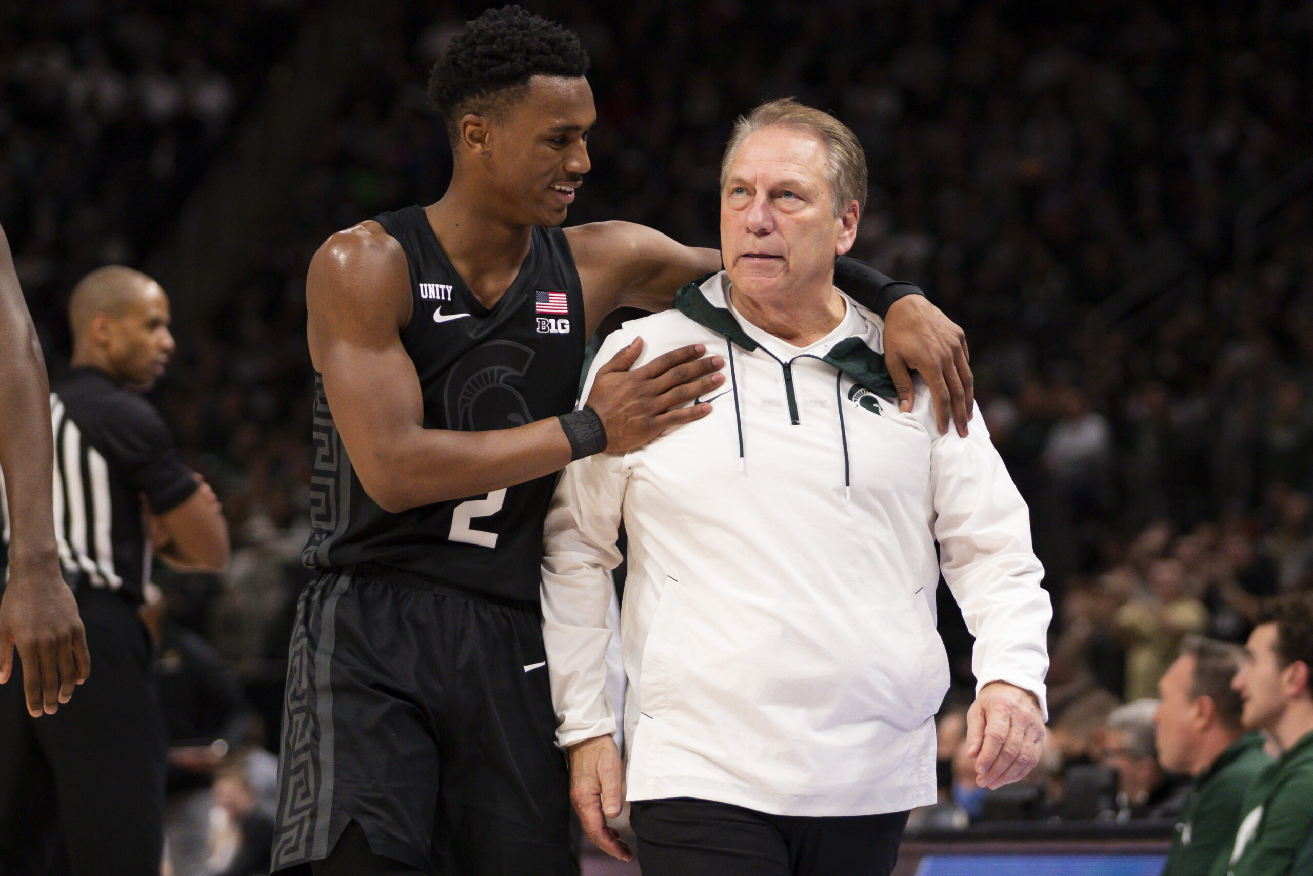 Michigan State basketball player Tyson Walker comfirts his coach Tom Izzo during a game